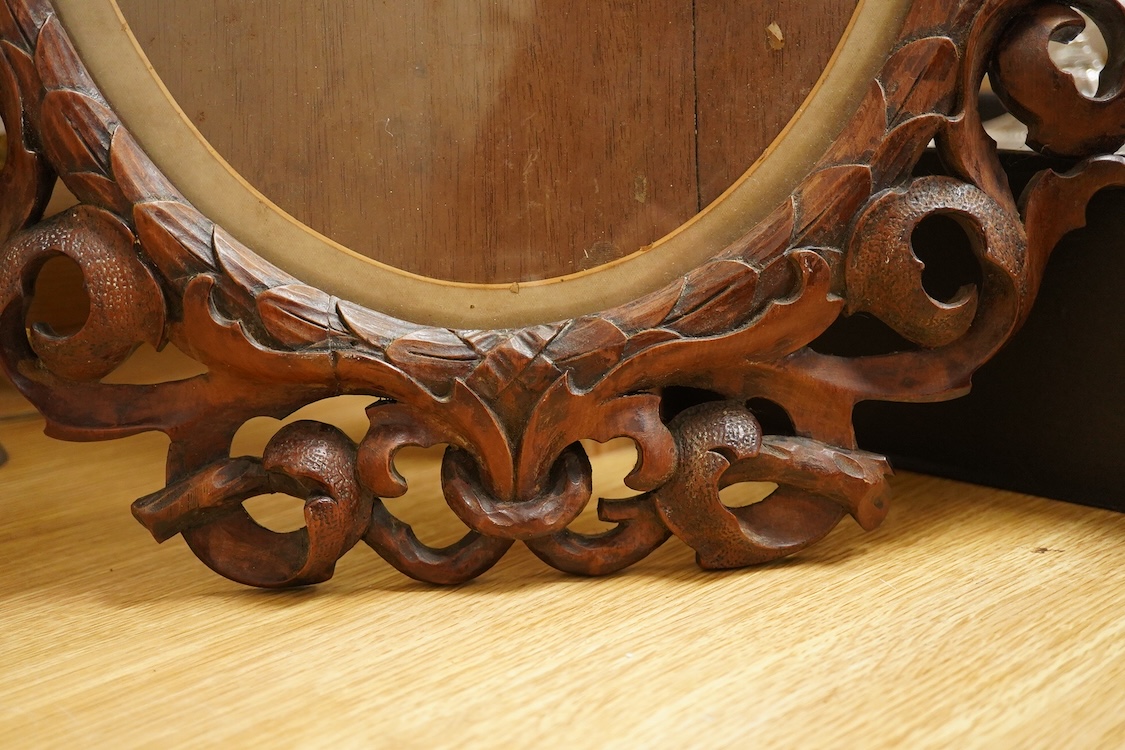 An oval carved wood mirror, 53cm high